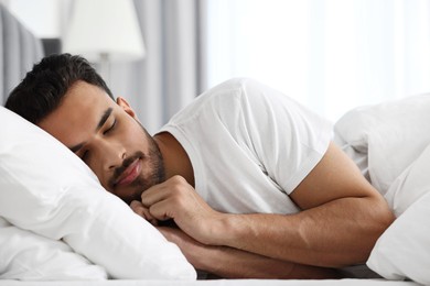 Handsome man sleeping in bed at morning