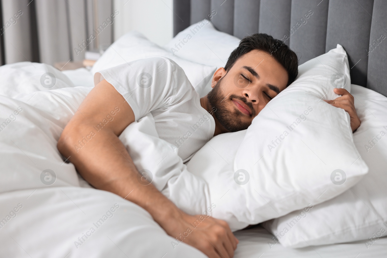 Photo of Handsome man sleeping in bed at morning