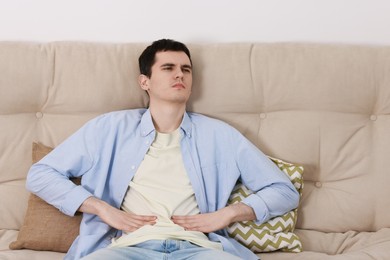 Man suffering from abdominal pain at home