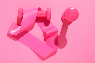 Photo of Dumbbells and fitness elastic band on pink background, flat lay