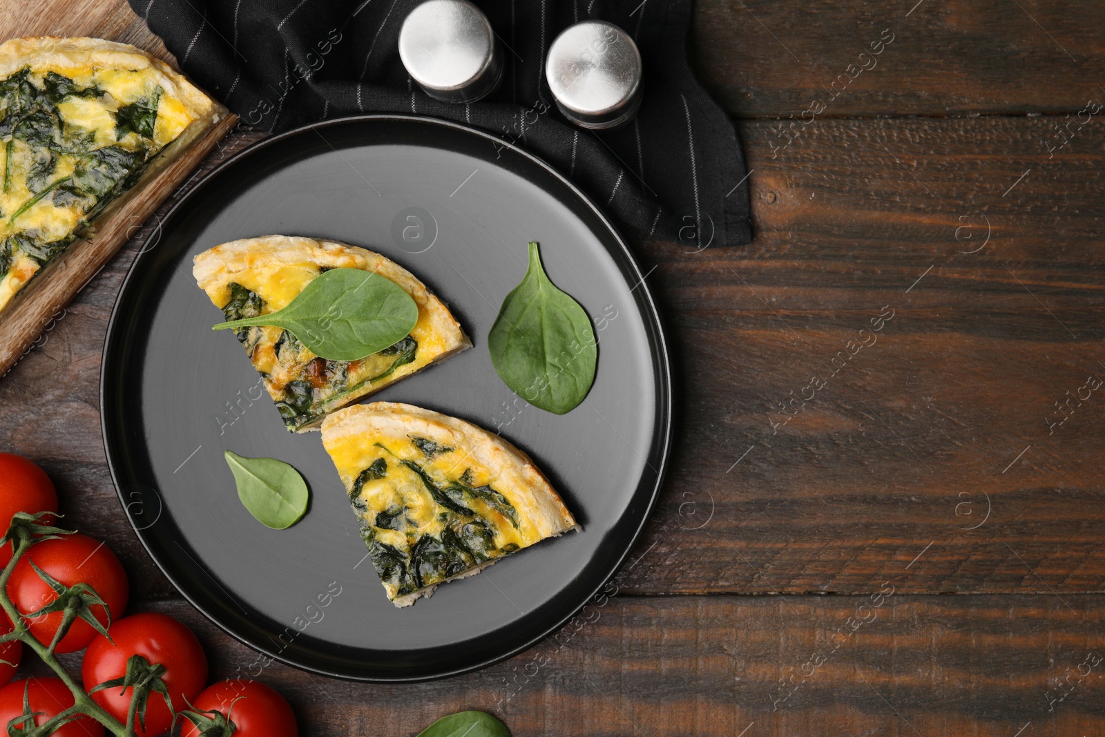 Photo of Pieces of delicious pie with spinach on wooden table, flat lay. Space for text