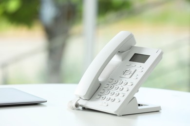 White telephone on table against blurred background