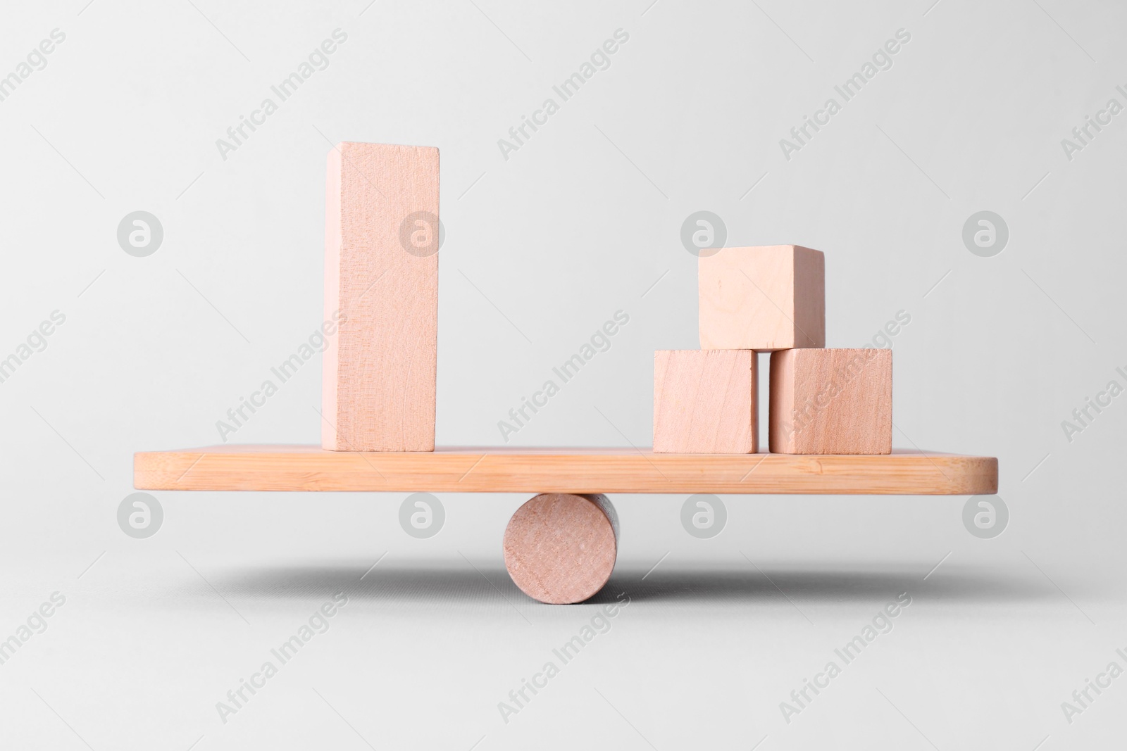 Photo of Equality concept. Seesaw scale with wooden blocks on light background