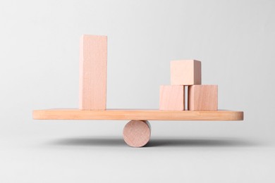 Equality concept. Seesaw scale with wooden blocks on light background