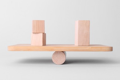 Equality concept. Seesaw scale with wooden blocks on light background