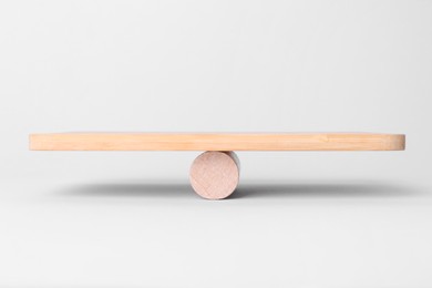 Photo of Equality concept. Wooden seesaw scale on light background