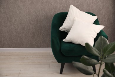 Photo of Soft pillows on armchair in living room. Space for text