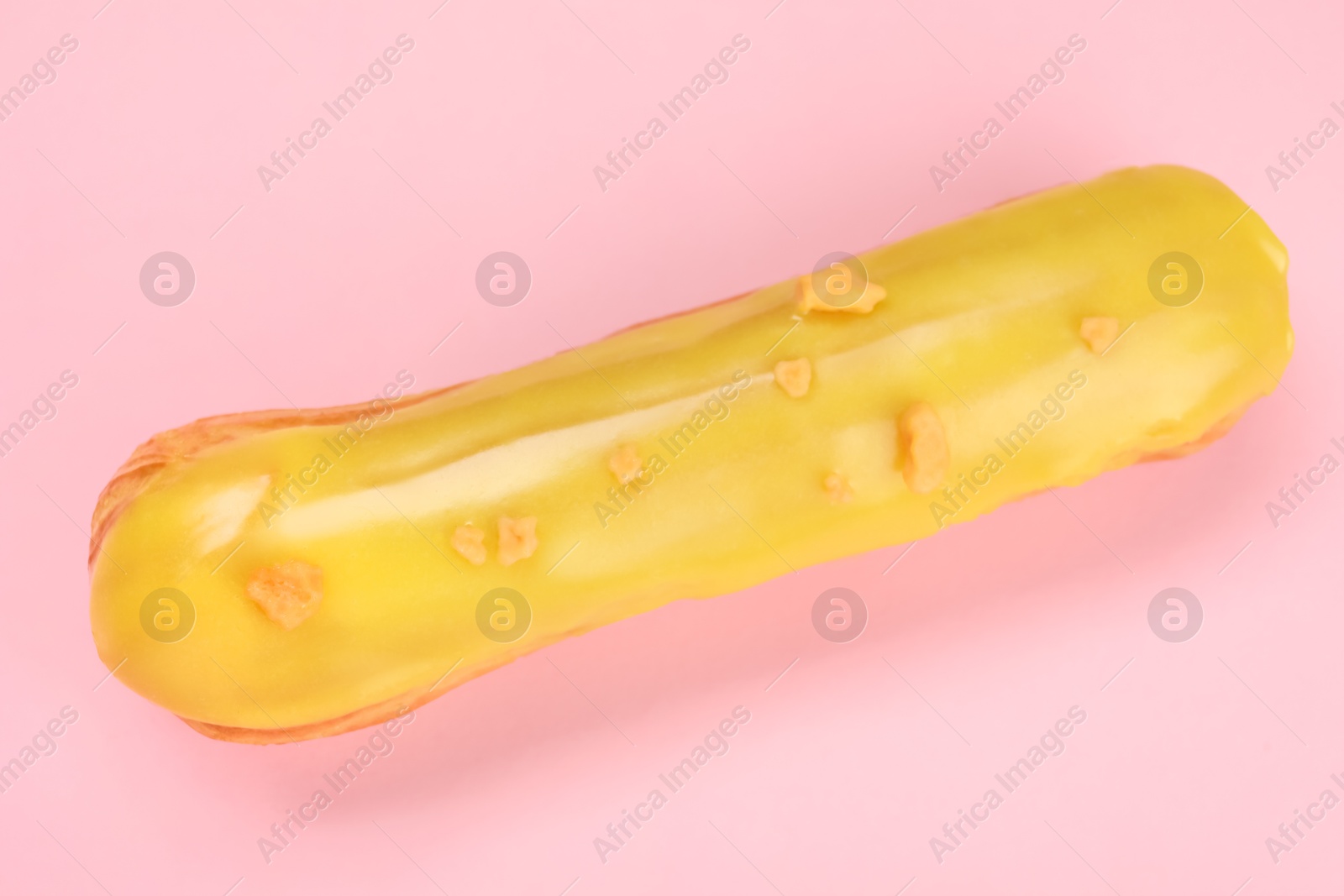 Photo of Delicious eclair covered with glaze on pink background, top view