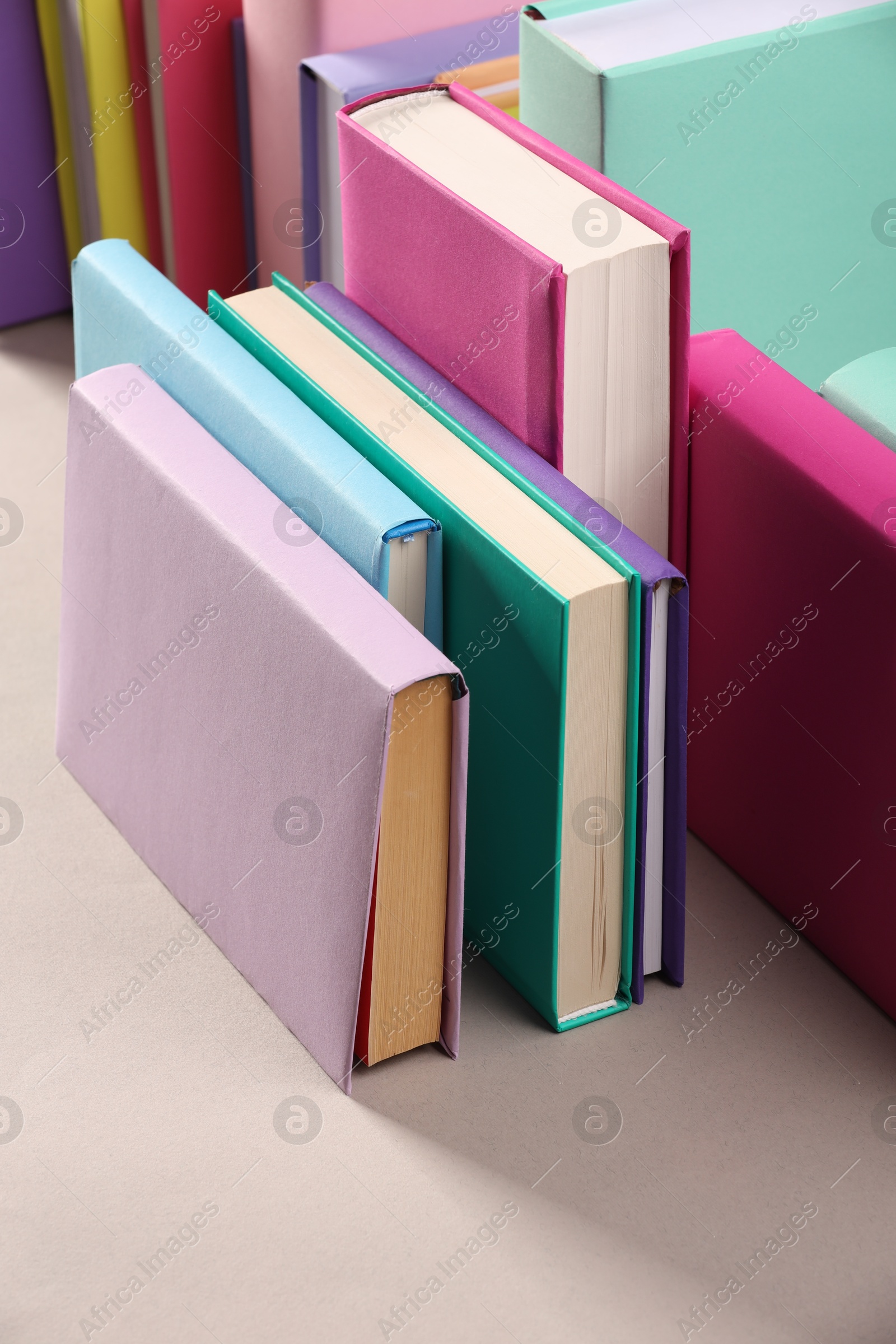 Photo of Many colorful books on beige background, closeup