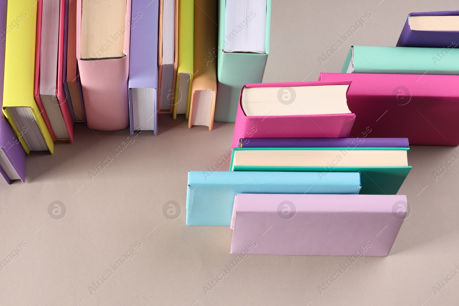 Photo of Many colorful books on beige background, above view