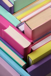 Many colorful hardcover books as background, closeup