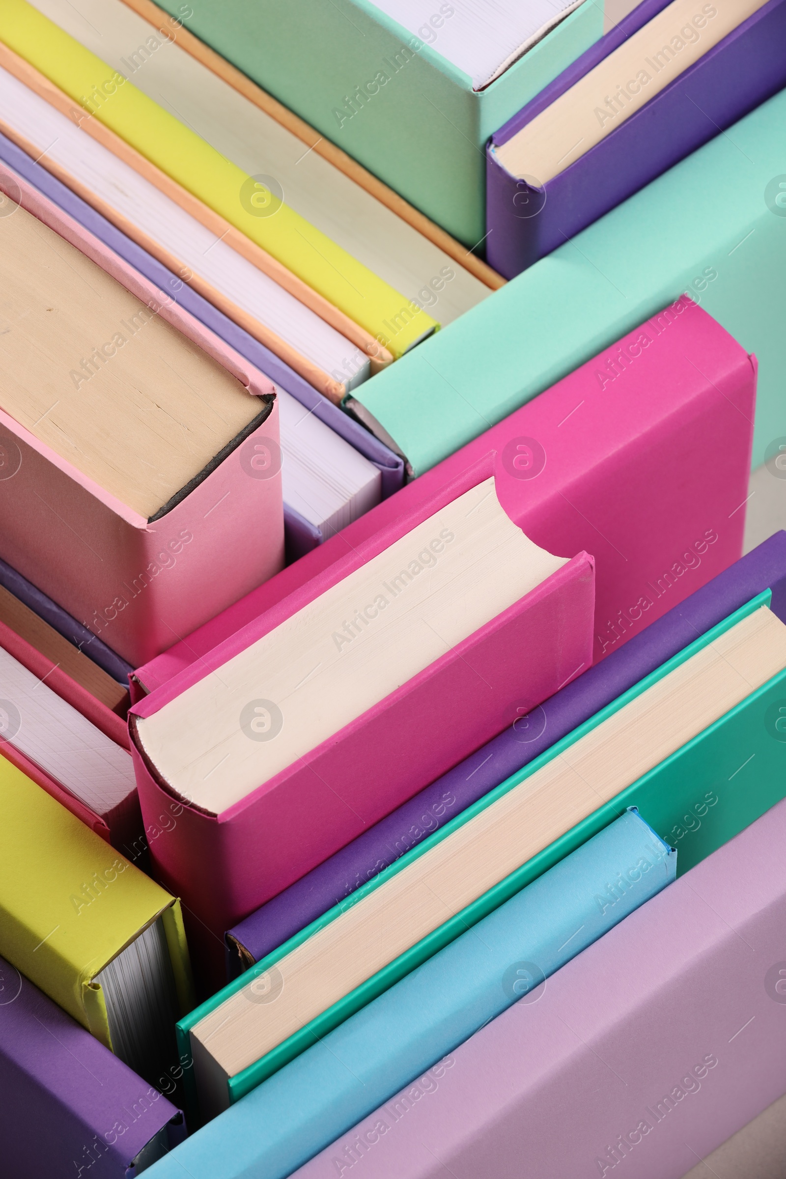 Photo of Many colorful hardcover books as background, closeup