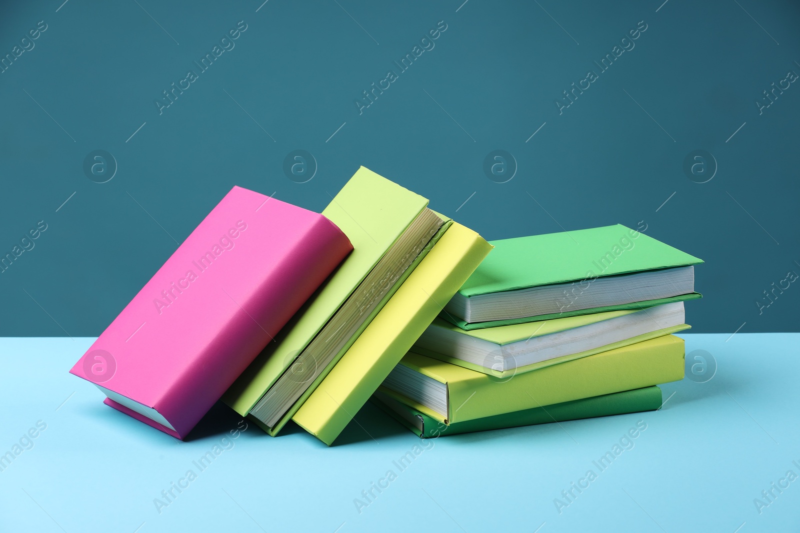 Photo of Many colorful books on light blue background