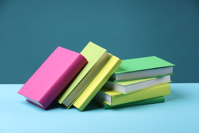 Photo of Many colorful books on light blue background