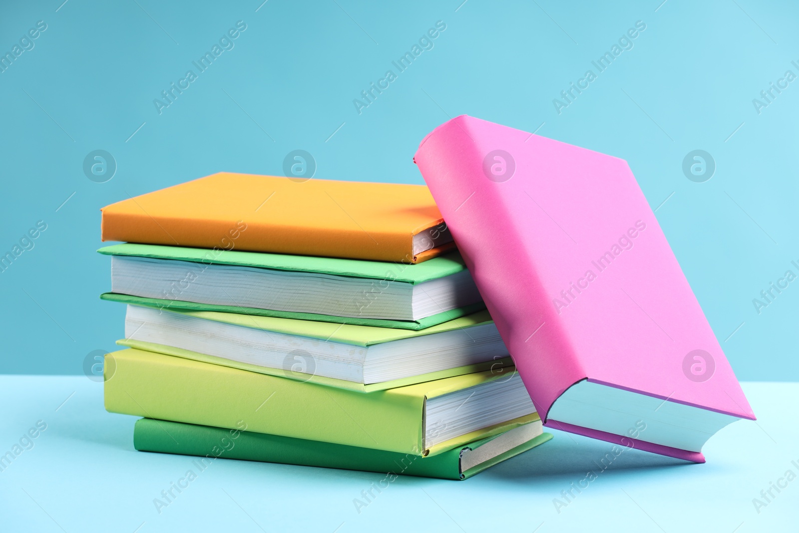 Photo of Many colorful books on light blue background