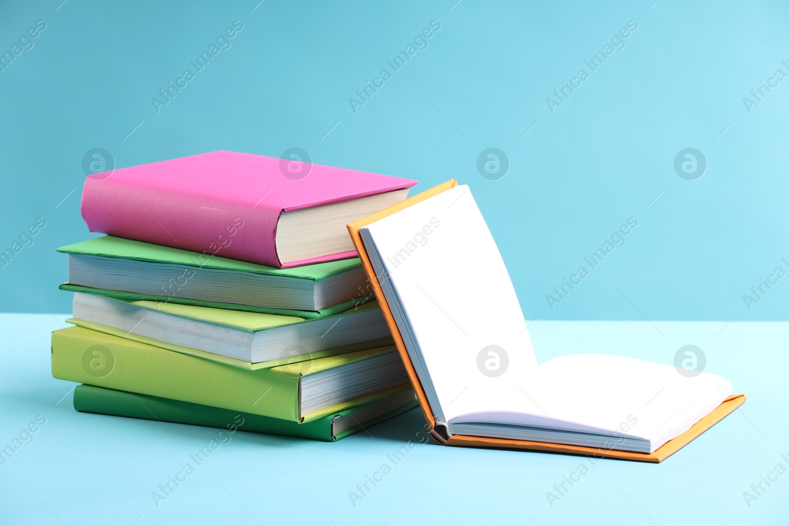 Photo of Many colorful books on light blue background