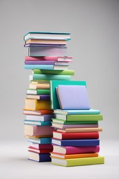 Photo of Stacks of colorful books on light grey background