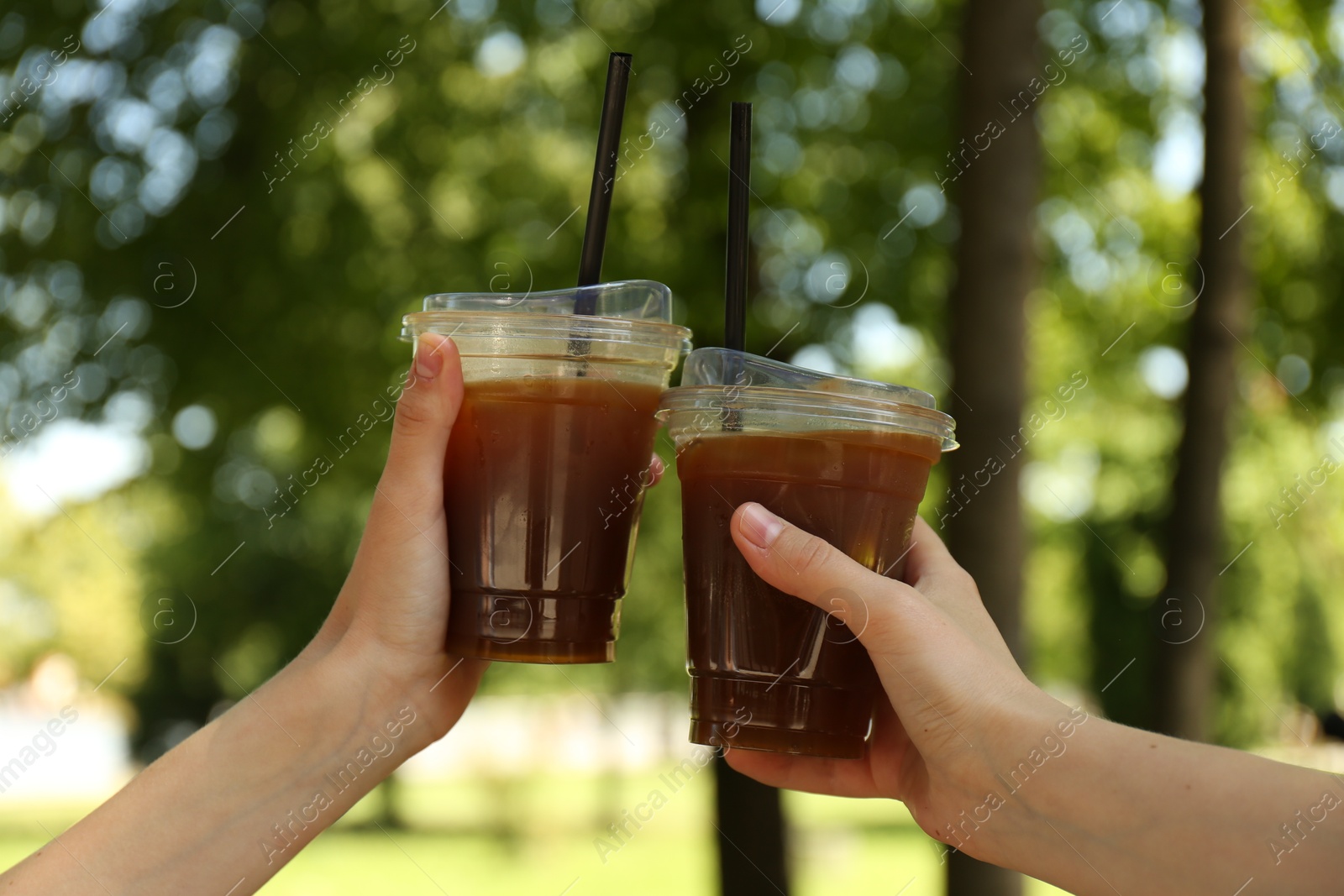 Photo of Women with tasty refreshing drinks outdoors, closeup