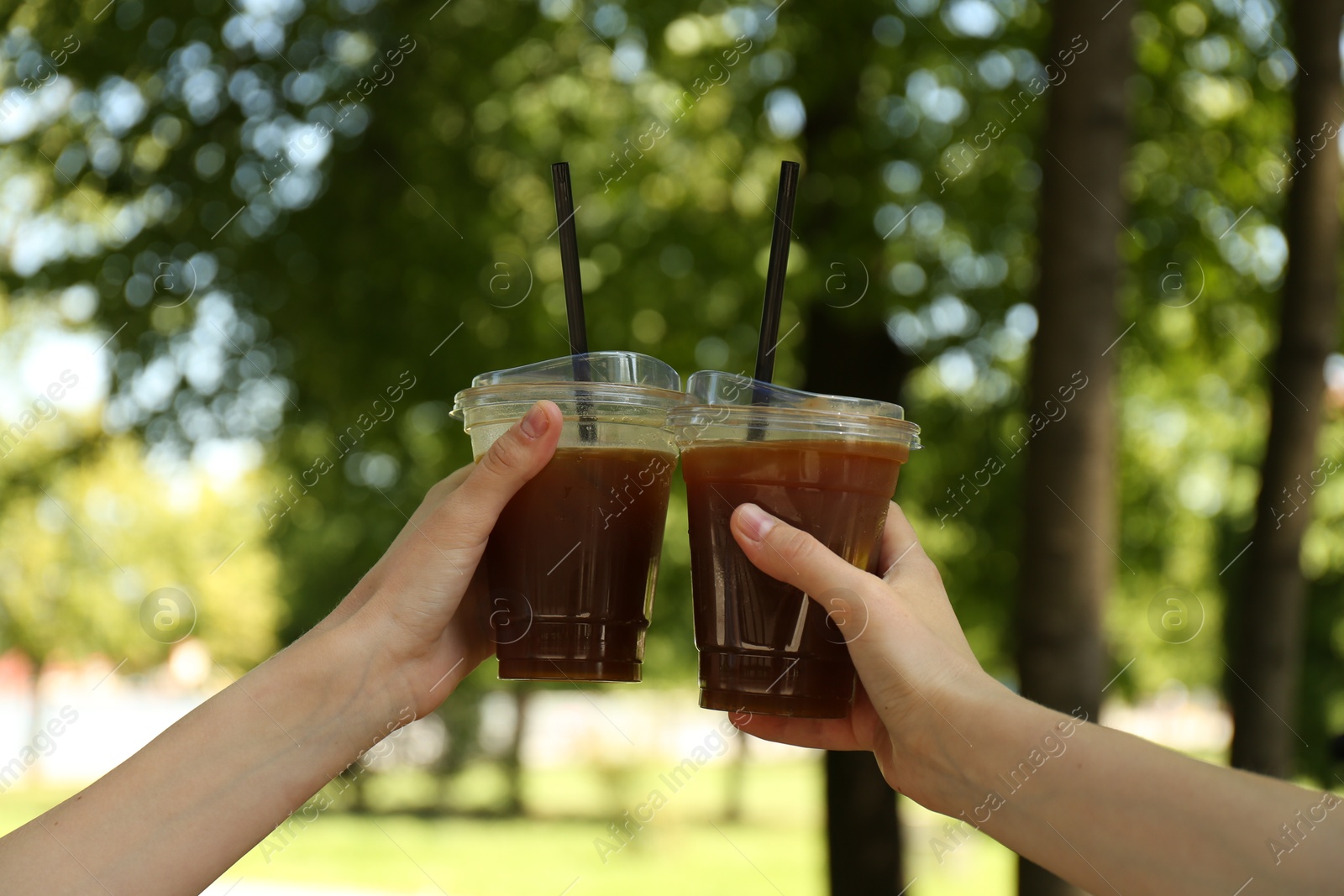 Photo of Women with tasty refreshing drinks outdoors, closeup