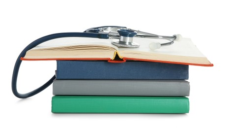 Stethoscope on stack of books against white background