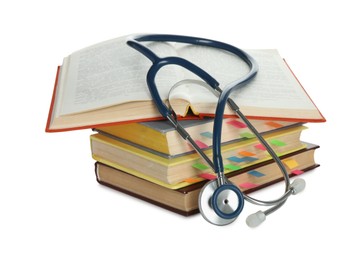 Stethoscope on stack of books against white background