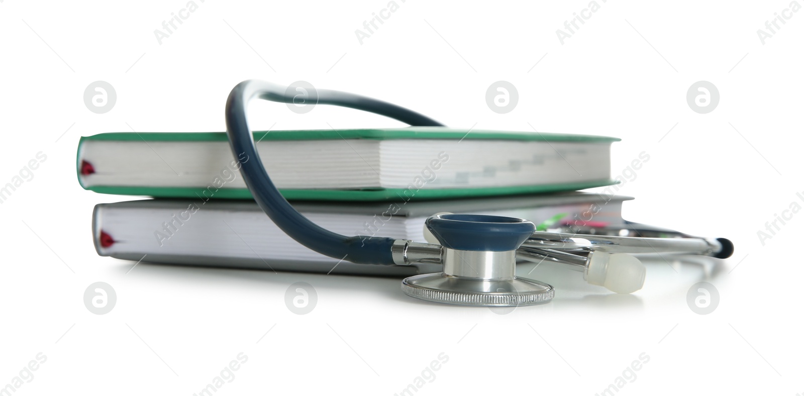 Photo of Stethoscope and stack of books isolated on white