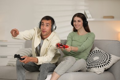 Couple playing video games with controllers at home