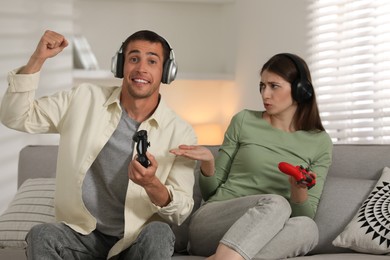 Couple playing video games with controllers at home