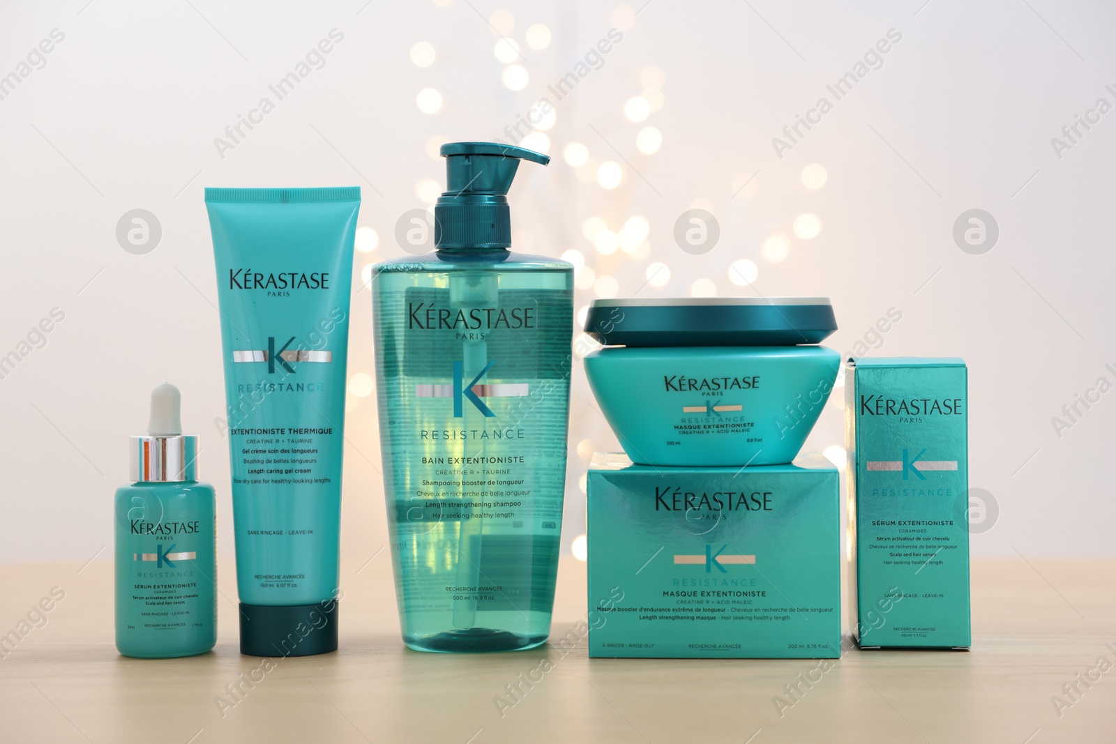 Photo of Leiden, Netherlands - June 11, 2024: Kerastase hair care cosmetic products on wooden table against light background with blurred lights