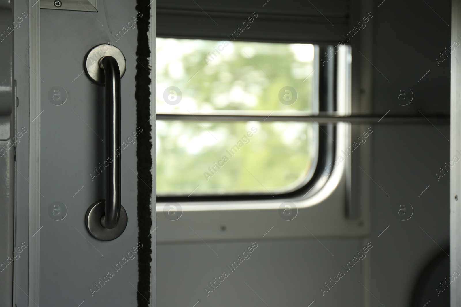Photo of White compartment door with metal handle in train car, closeup