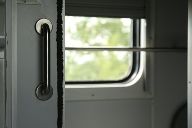 White compartment door with metal handle in train car, closeup