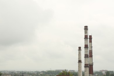 Modern power station in city on cloudy day, space for text