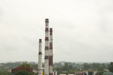 Modern power station in city on cloudy day, space for text