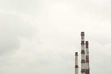 Modern power station against cloudy day, space for text