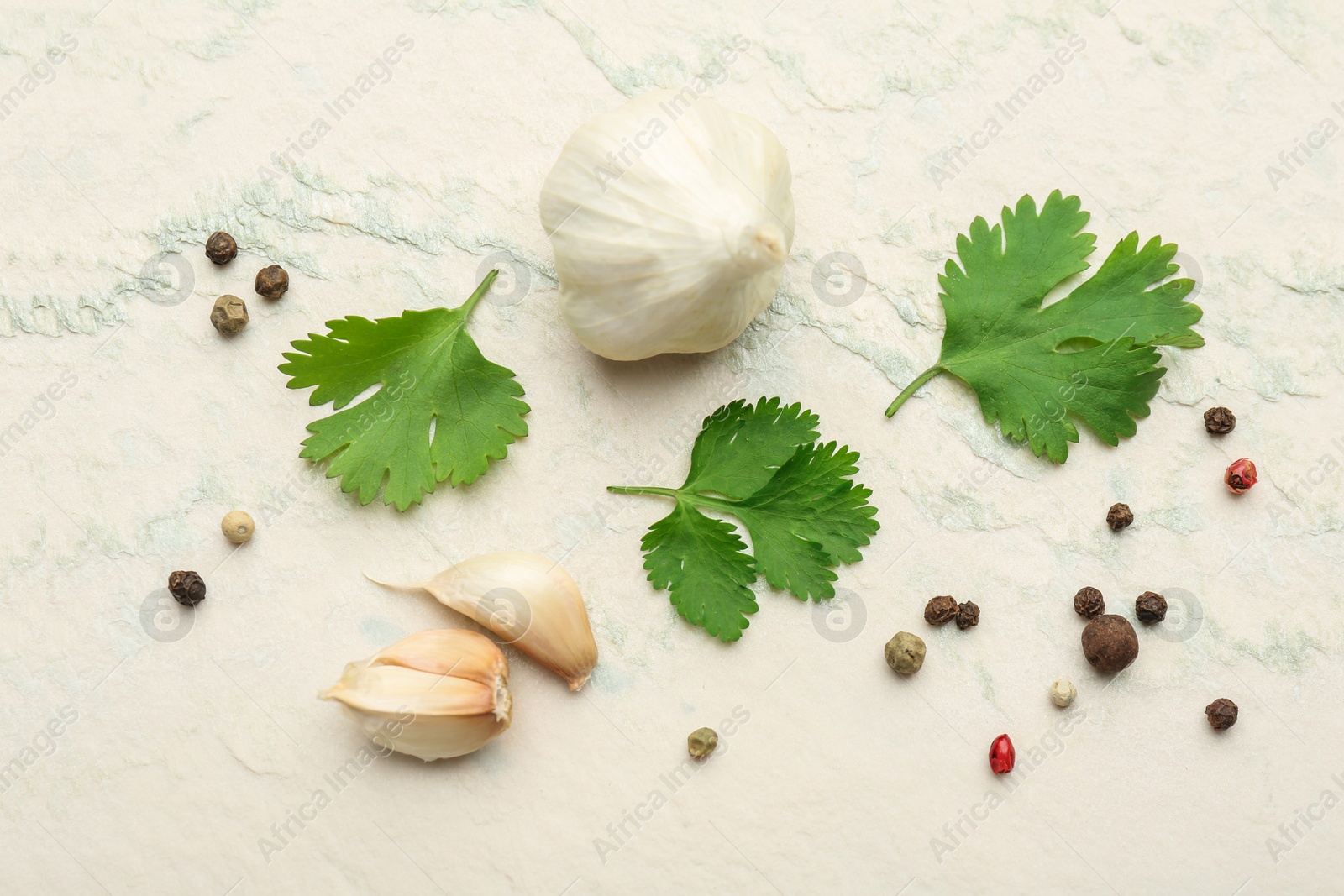 Photo of Fresh coriander leaves, garlic and peppercorns on light textured table, flat lay