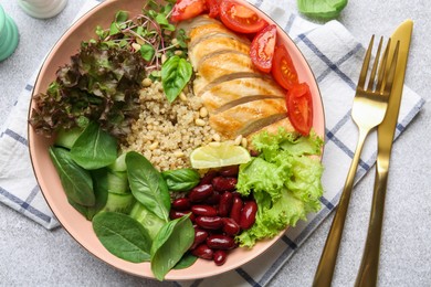 Photo of Healthy meal. Tasty vegetables, quinoa and chicken breast in bowl on white table, flat lay