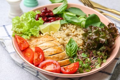 Photo of Healthy meal. Tasty vegetables, quinoa and chicken breast in bowl on white table, closeup