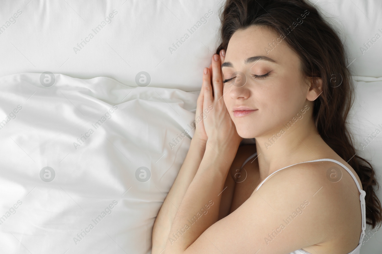 Photo of Bedtime. Beautiful woman sleeping on bed in morning, top view. Space for text