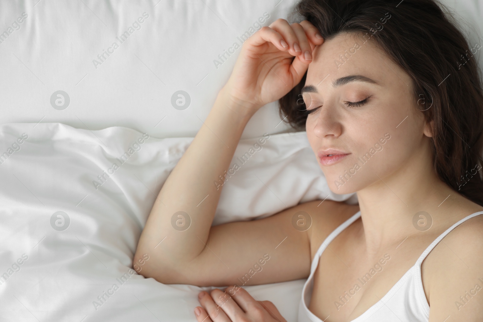 Photo of Bedtime. Beautiful woman sleeping on bed in morning, top view. Space for text