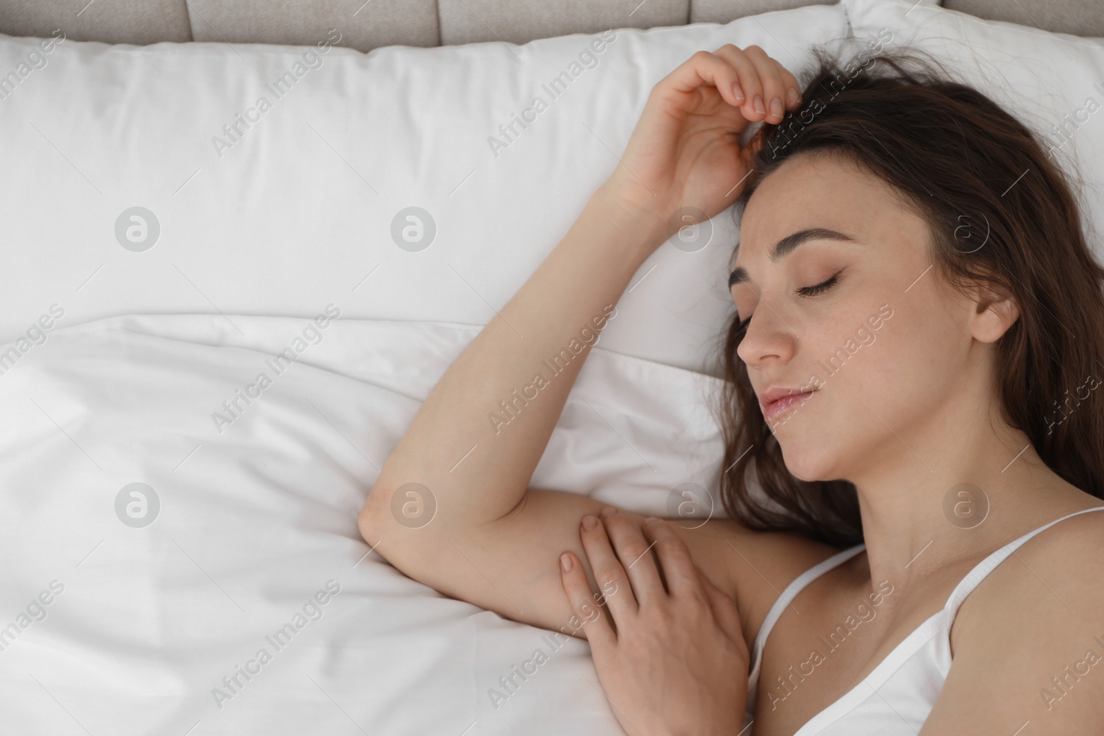 Photo of Bedtime. Beautiful woman sleeping on bed in morning, top view. Space for text