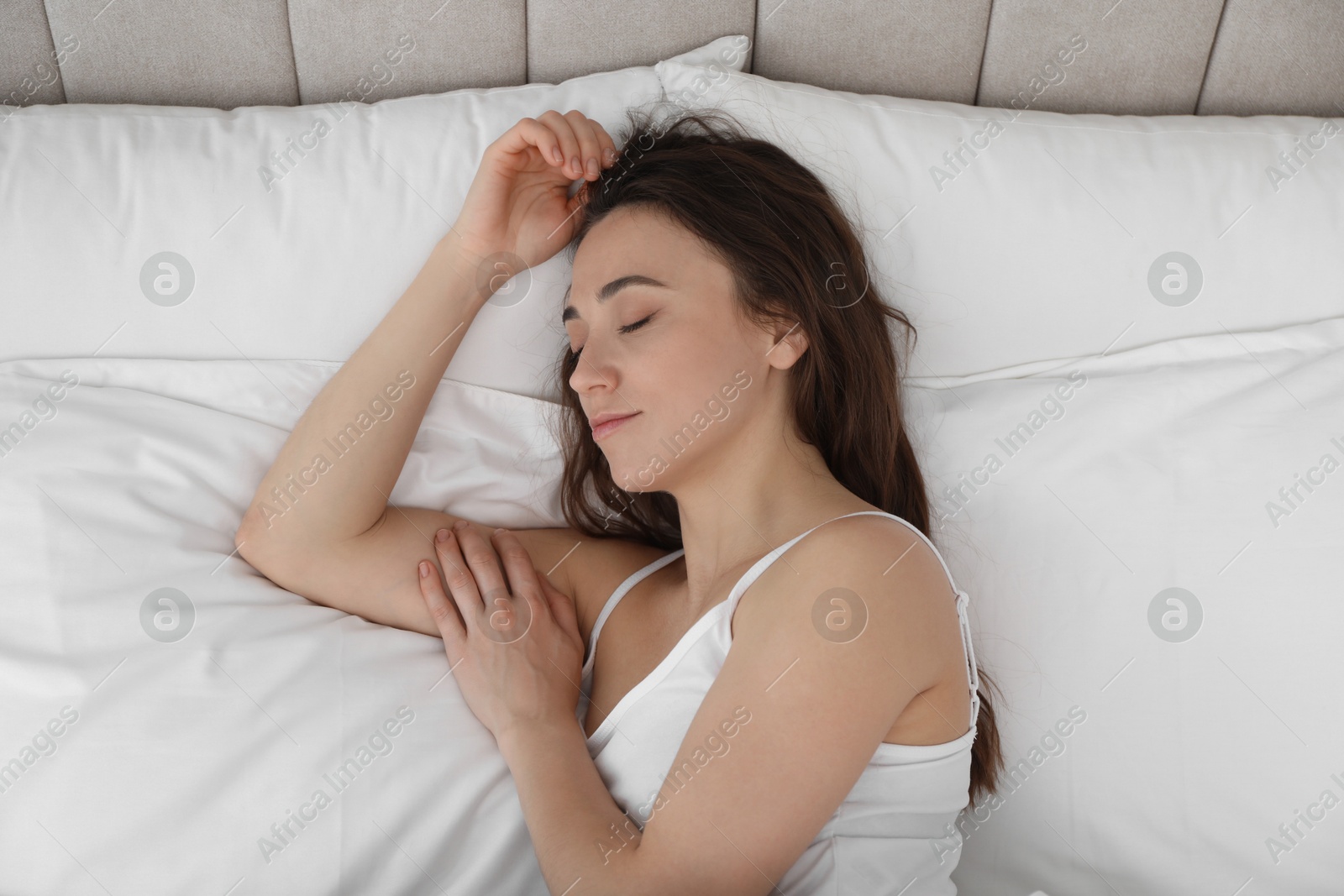 Photo of Bedtime. Beautiful woman sleeping on bed in morning, top view