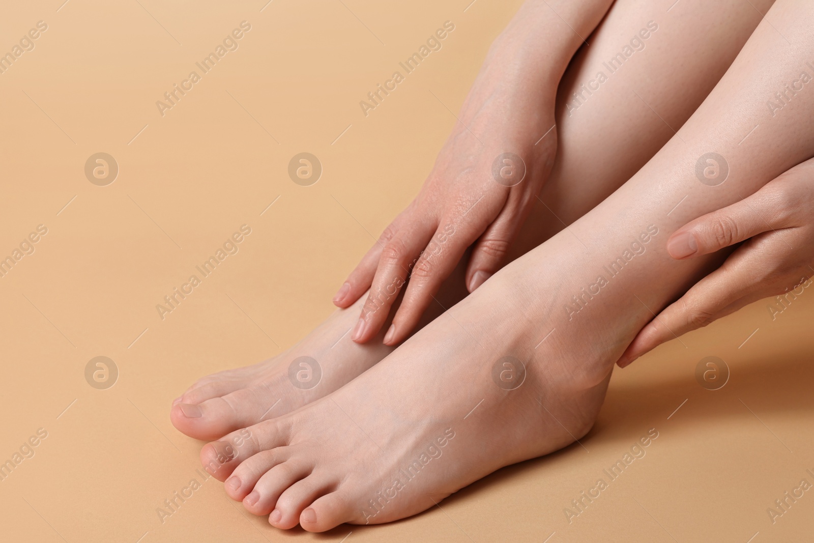 Photo of Closeup view of woman`s groomed feet after care procedure on beige background