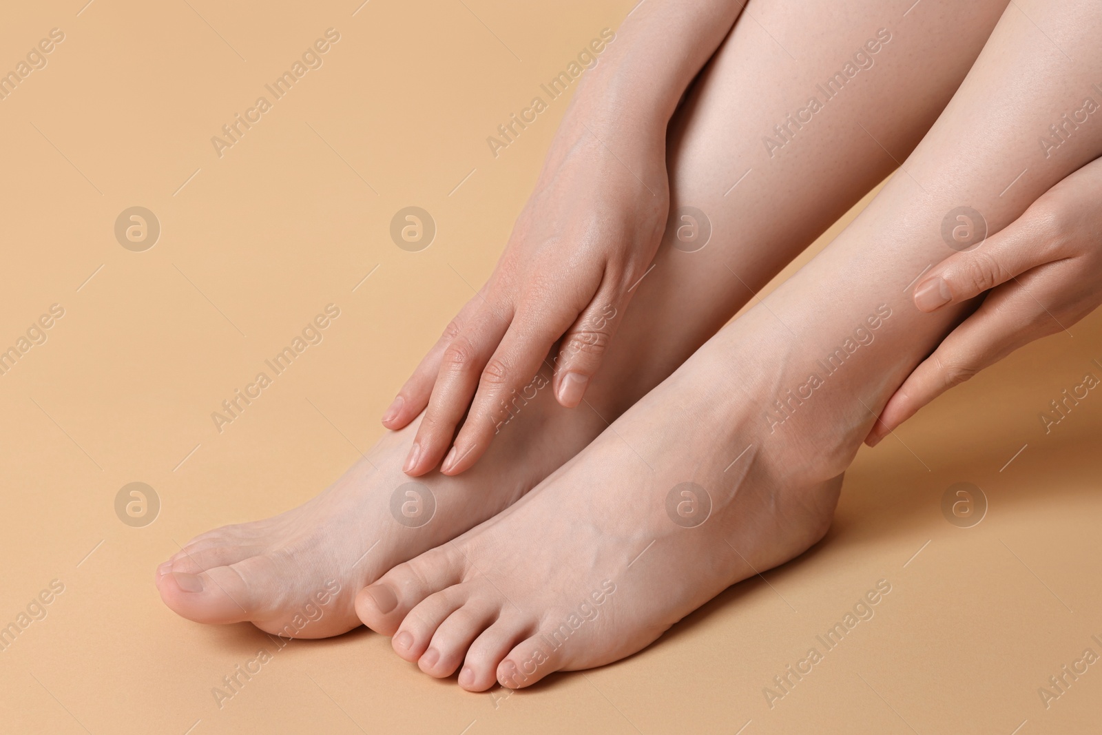 Photo of Closeup view of woman`s groomed feet after care procedure on beige background