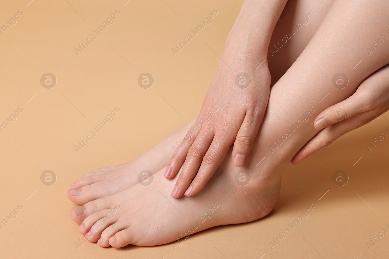 Photo of Closeup view of woman`s groomed feet after care procedure on beige background