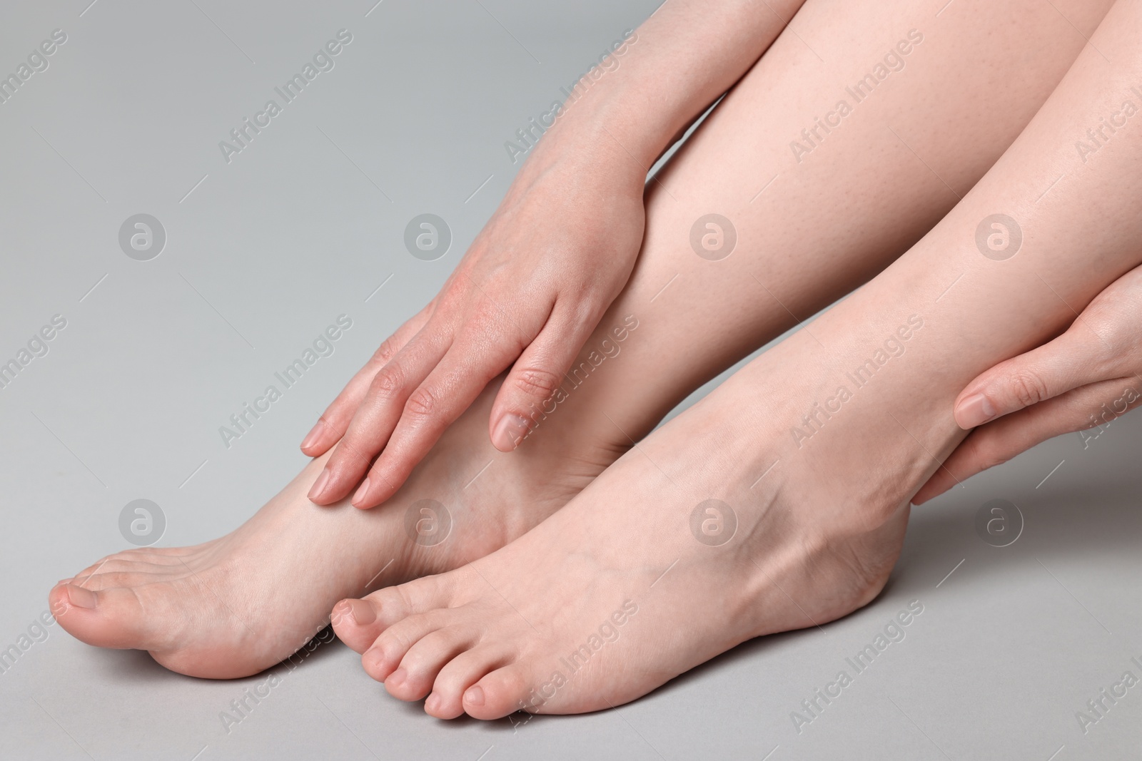 Photo of Closeup view of woman`s groomed feet after care procedure on grey background