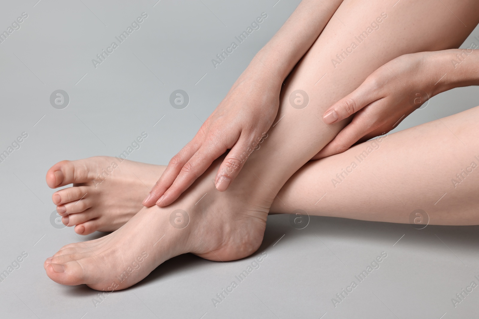 Photo of Closeup view of woman`s groomed feet after care procedure on grey background