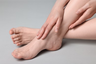 Photo of Closeup view of woman`s groomed feet after care procedure on grey background