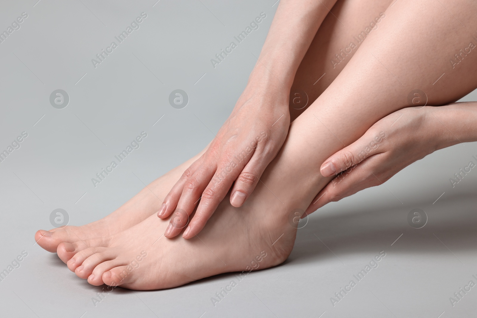 Photo of Closeup view of woman`s groomed feet after care procedure on grey background