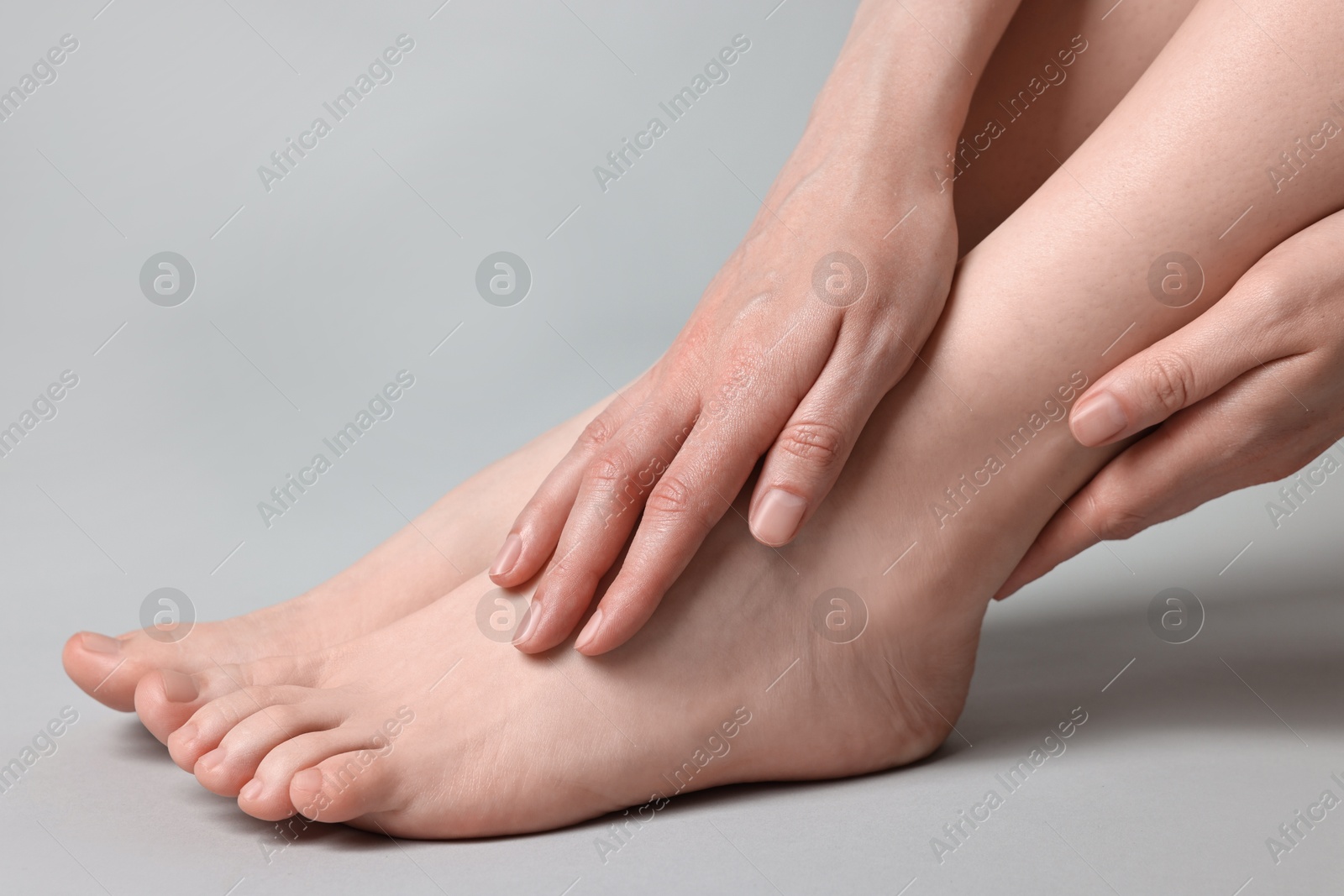 Photo of Closeup view of woman`s groomed feet after care procedure on grey background