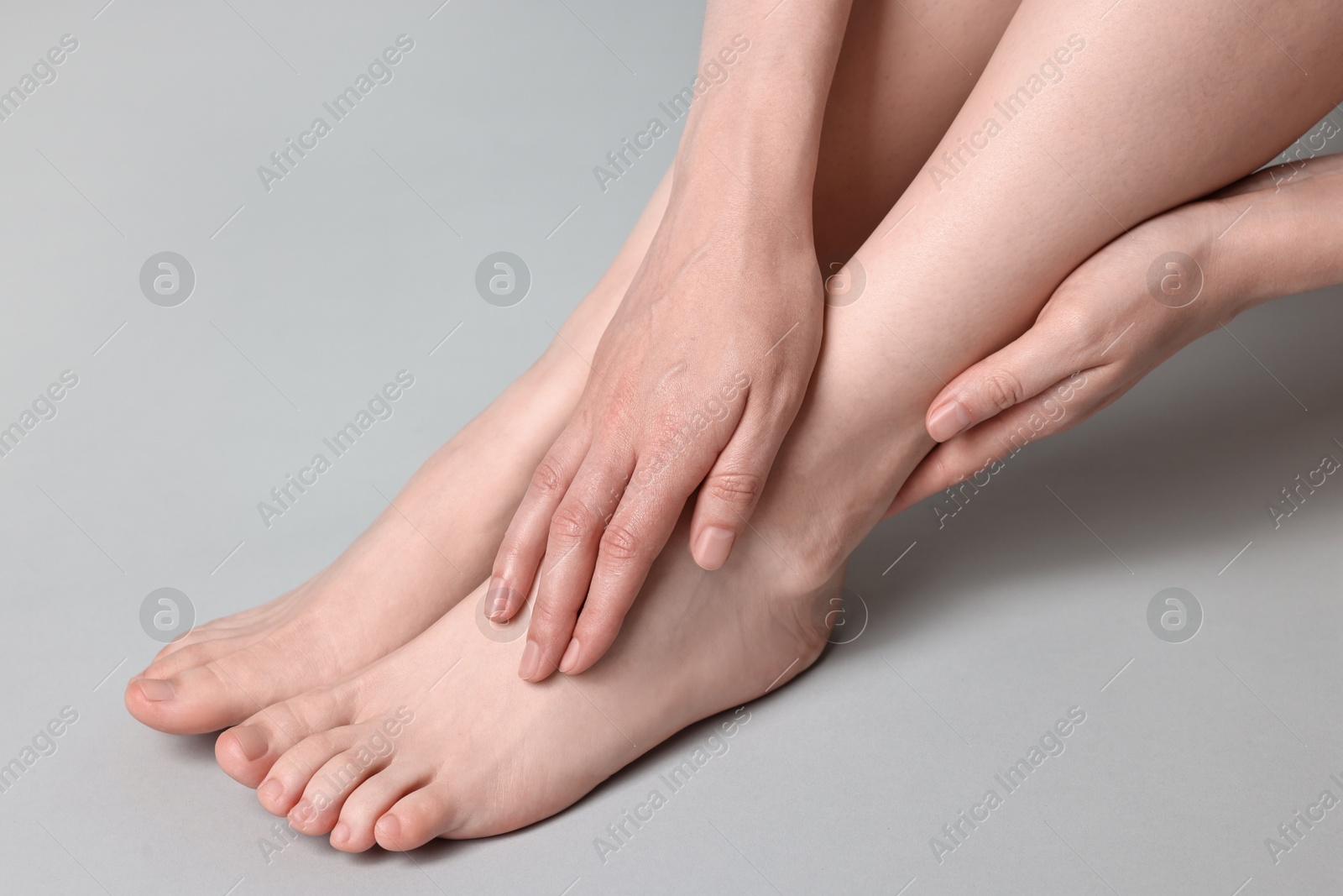 Photo of Closeup view of woman`s groomed feet after care procedure on grey background